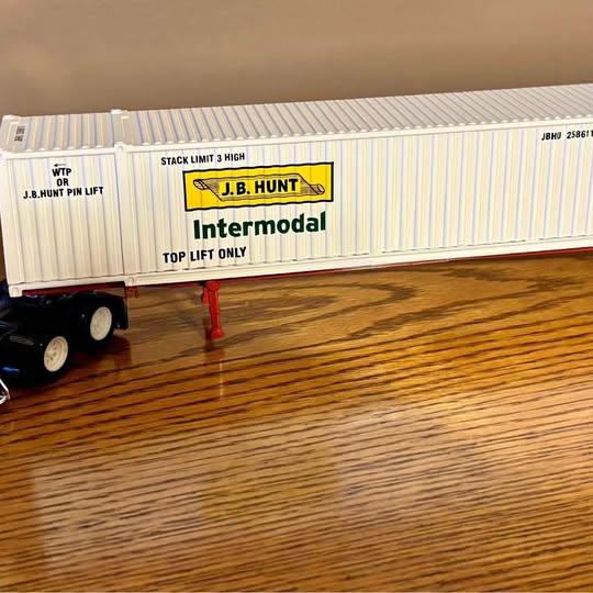 White and gray intermodal tractor trailer with yellow J.B. Hunt Intermodal panel