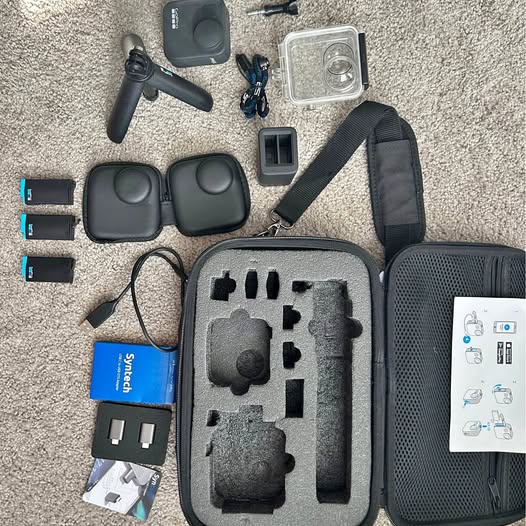 Hard-shell action camera travel case with mounts, battery charger, and cables