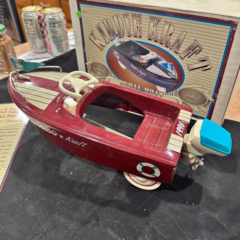Red diecast pedal car toy with steering wheel and white wheels