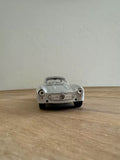 Silver 1954 diecast coupe model toy car, front view with grille and headlights