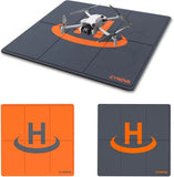 Weighted drone landing pad mat, dark gray with orange landing circle and fold lines