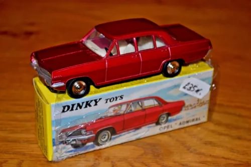Red diecast car model with Dinky Toys Atlas box and windowed front