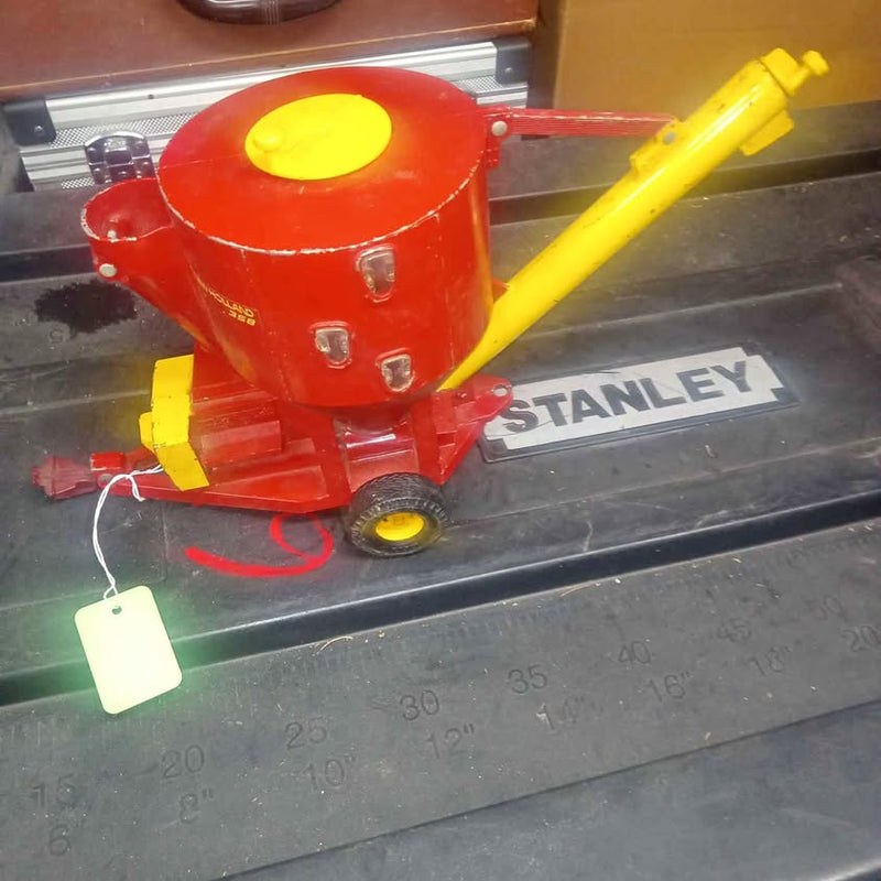 Red and yellow diecast concrete mixer model with rotating drum and small base