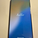 White iPhone 16 Pro Max front display with 'hello' and swipe up to open