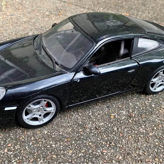 Black diecast metal model car, side view with silver wheels