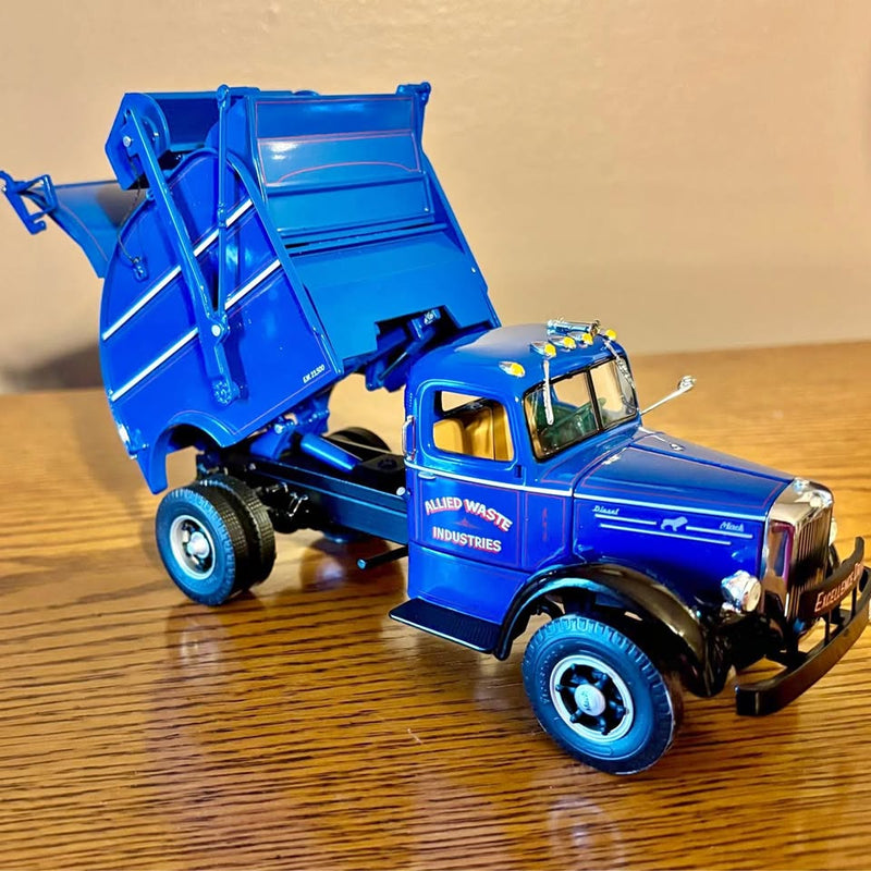 Blue diecast sanitation truck replica with open rear dump bed and printed side logo