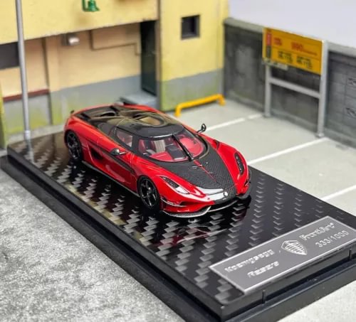 Red sports model diecast car with black accents, glossy body on display base