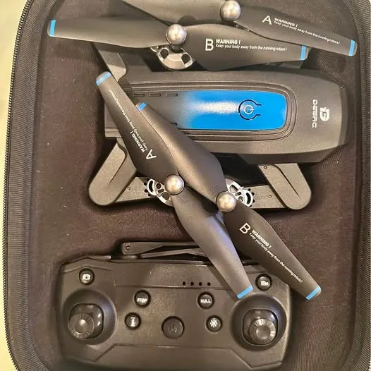 Foldable quadcopter drone with blue accents and remote controller in carrying case