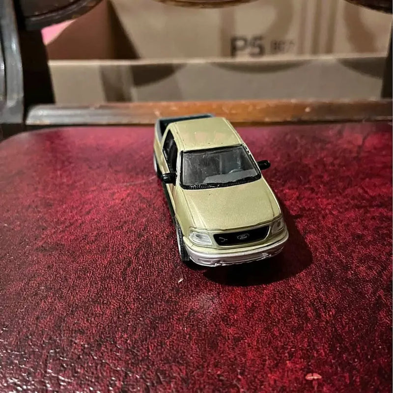 Ford F-150 diecast pickup model, light green, front view with headlights and grille