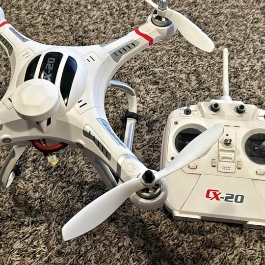 White CX-20 quadcopter drone with blue accents and antennas, red CX-20 label