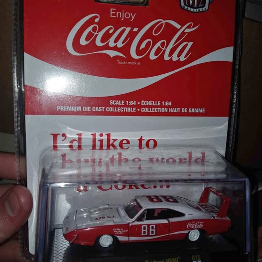 Coca-Cola red diecast model car with number 86, in clear blister pack