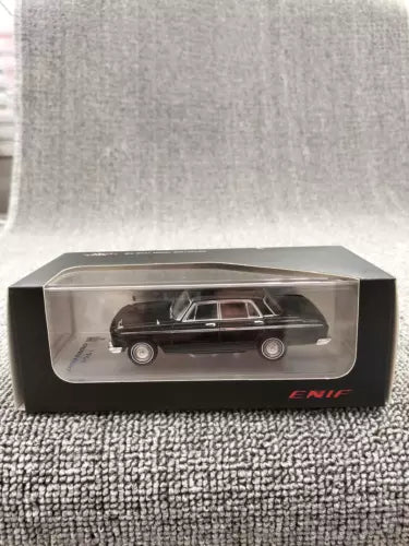 Black diecast sedan model in clear display case with ENIF logo