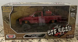 Red die-cast off-road pickup truck model in retail box, 1:24 scale