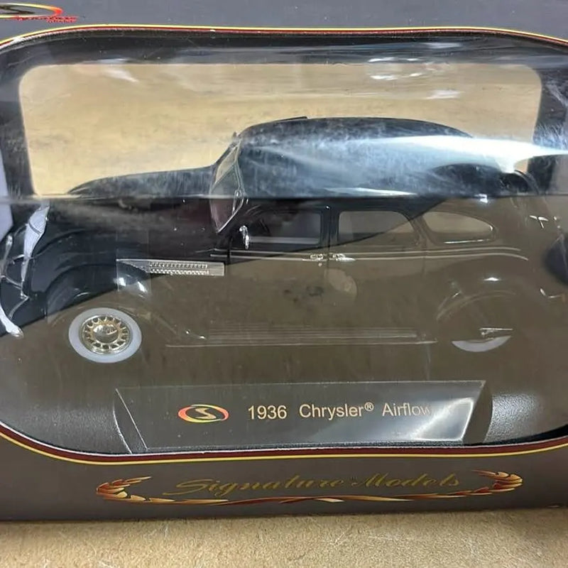 Collectible diecast 1936 Chrysler Airflow car, dark green with chrome wheels, in display case