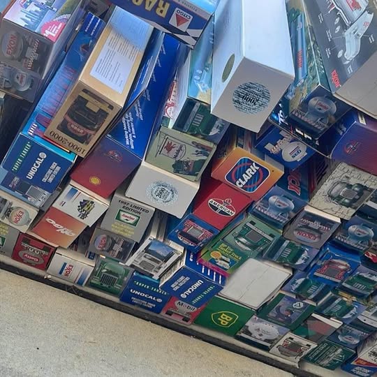 Diecast toy cars and trucks in retail boxes on display shelf