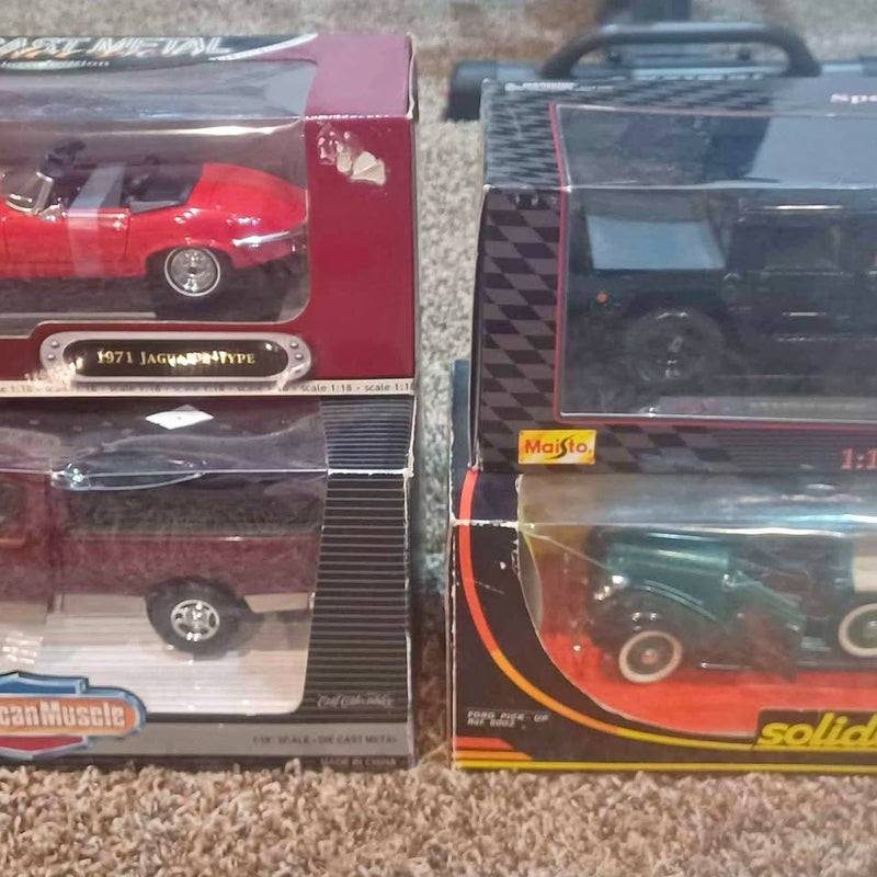 Two diecast vehicle model boxes, one red and one dark blue, shown side by side