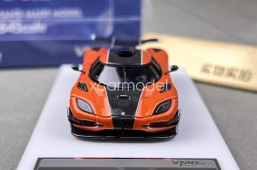 Orange and black diecast racing model car with front grille and headlights