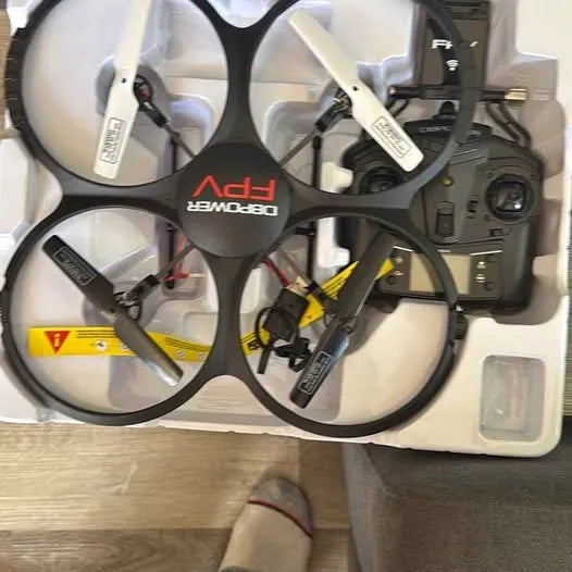 Quadcopter drone with four propellers, foldable arms, and camera module