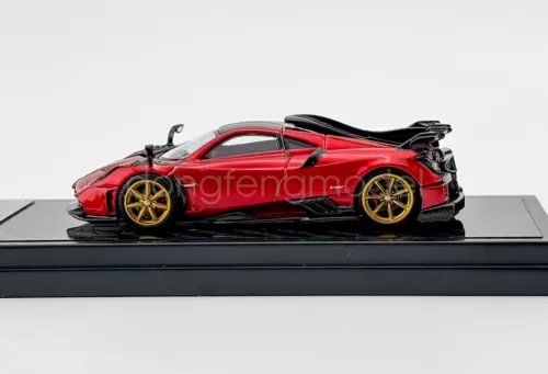 1:64 scale red sports diecast car with black rear wing, on display base