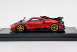 1:64 scale red sports diecast car with black rear wing, on display base