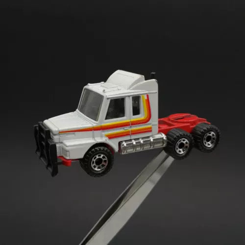 White diecast semi truck toy with multicolor stripe cab, detailed front and wheels