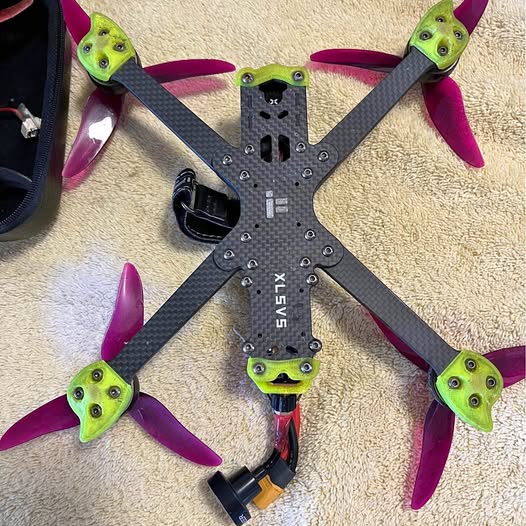 Quadcopter drone frame with 4 propellers, purple blades and green hubs