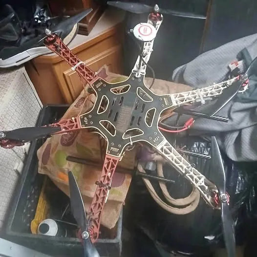 RC quadcopter drone with red and white frame, mounted propellers and front camera mount
