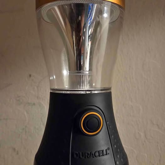 Black and silver handheld device with circular orange-ring button