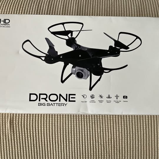 Black small drone with four rotors and front camera lens