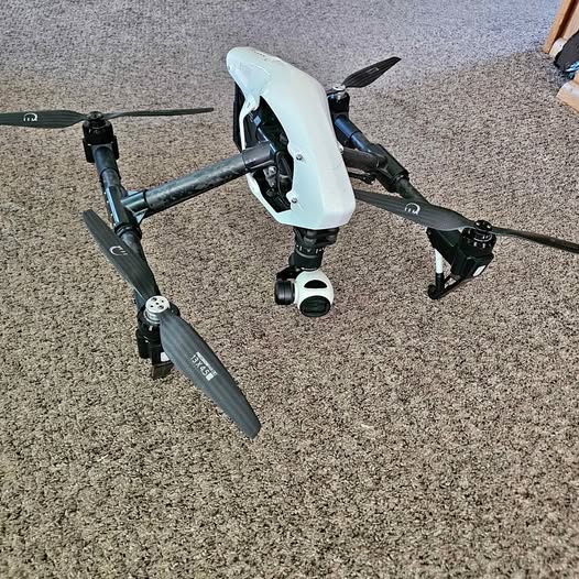 White quadcopter drone with camera and folding propellers
