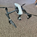 White quadcopter drone with camera and folding propellers