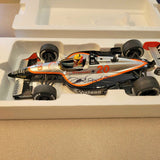 Orange and white #20 diecast IndyCar model with front and rear wheels in box