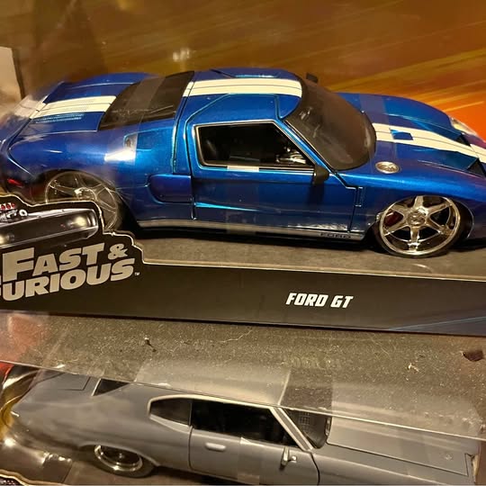 Blue diecast sports car with black hood scoop, chrome wheels; Ford GT on base