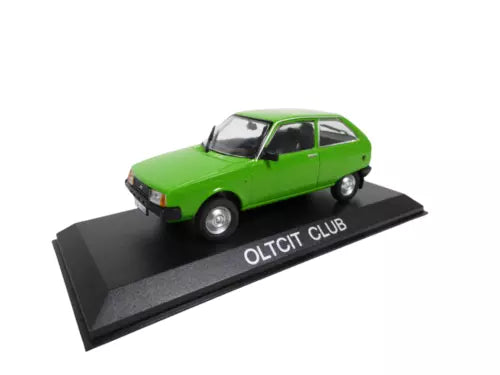 Green diecast model car with black display base, front-left view