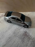 Silver metal diecast mini van model, side view with dark windows and black wheels