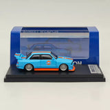 Blue diecast BMW E30 M3 model car in clear display case on black base