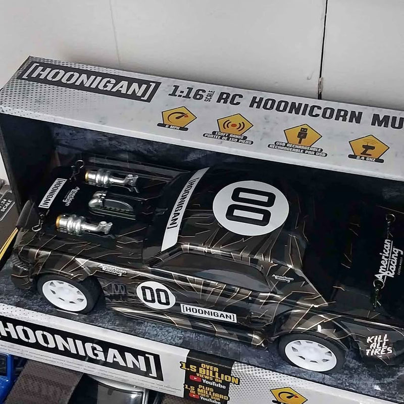 Black diecast race car with white graphics, number 00, in retail box