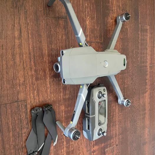 Folded-arm drone with white body and front camera gimbal, top view