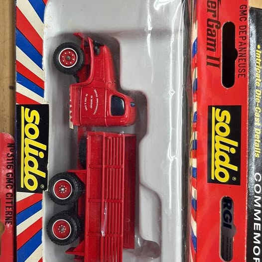 Red diecast fire truck in box, front and side view, detailed wheels and ladder