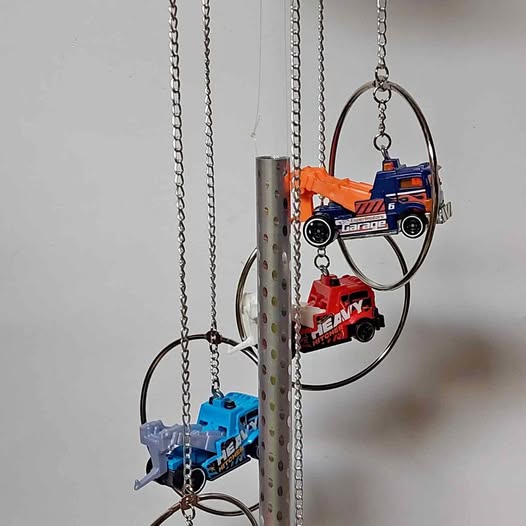 Diecast wind chime with metal rings and hanging miniature trucks in blue and orange