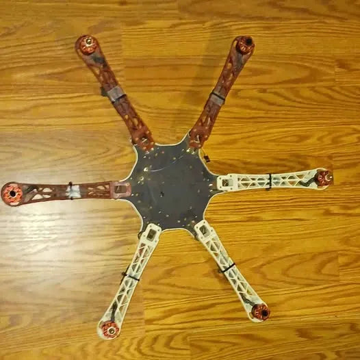 Quadcopter drone with four prop arms, metal frame and copper-colored tips