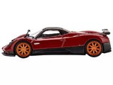 Red diecast sports car model with black aero kit and orange wheels, side view