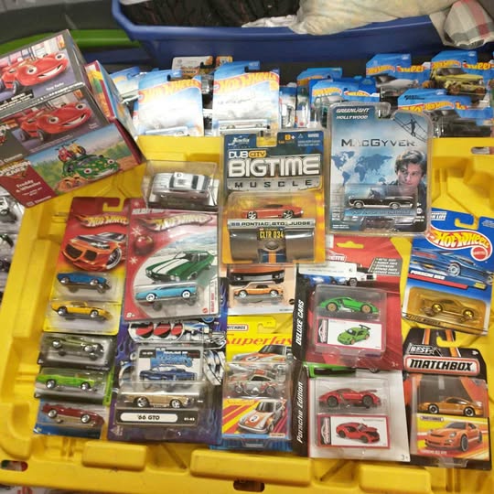 Assorted diecast toy cars in blister packs on a display tray