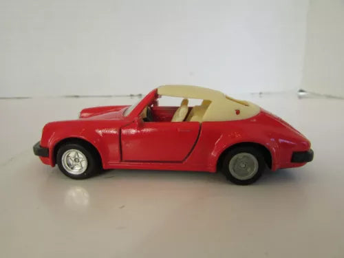 Red diecast toy sports car with open soft top, side view