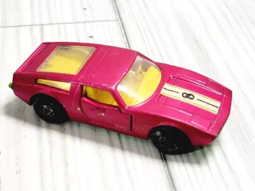 Hot Wheels 1972 Maserati Bora diecast car, pink body with yellow windows and stripe