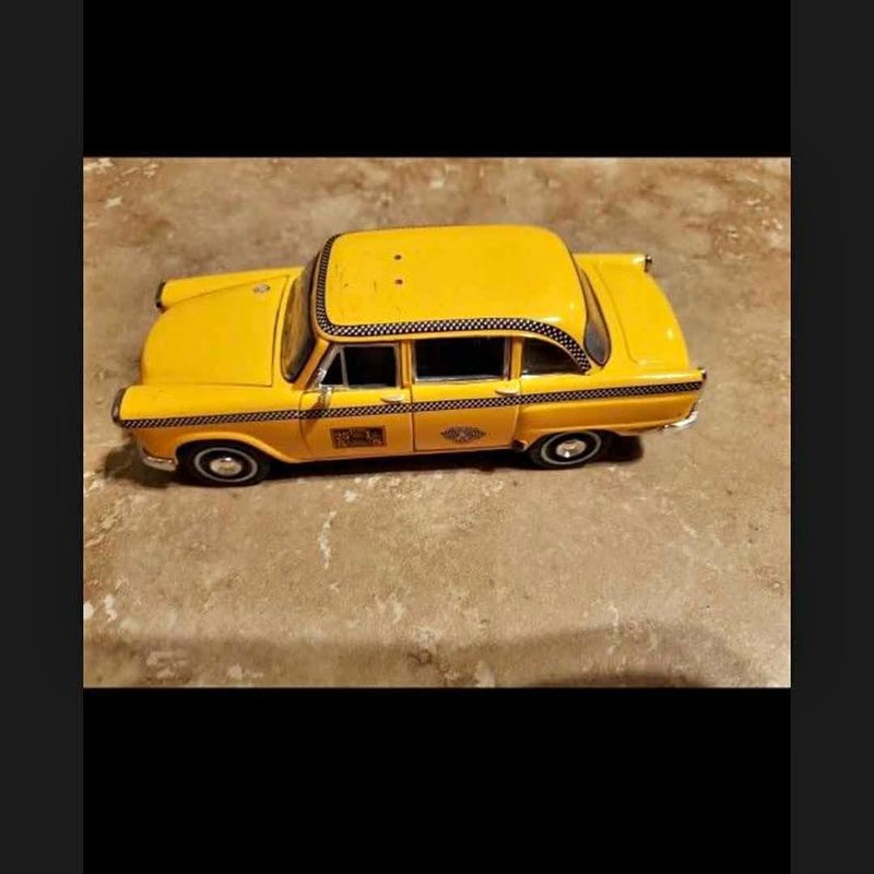 Yellow 1963-style diecast car model with black grille and white roof detail