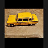 Yellow 1963-style diecast car model with black grille and white roof detail