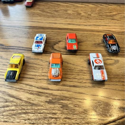 Set of six vintage diecast toy cars, colorful bodies with printed number details.