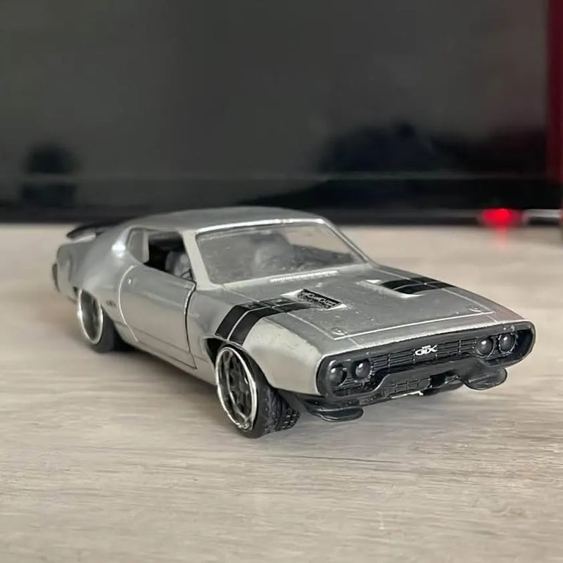 Silver diecast car model with black hood stripes and front grille detail