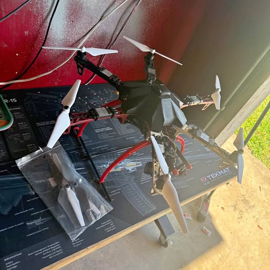 DJI flame f550 quadcopter drone with spinning propellers, black body and red arms